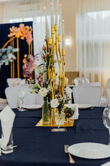 Elegant floral table centerpiece with golden candlesticks for a sophisticated dining ambiance.