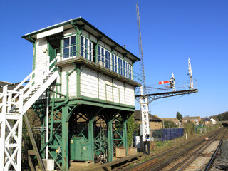 Old fashioned old retro rural railway signal box with a diminishing track in the background in England UK, train travel destination stock photo image