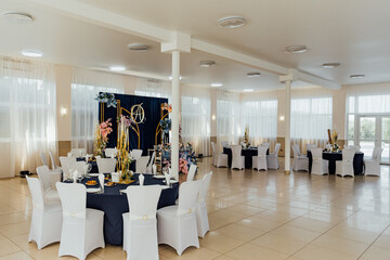 Elegant banquet hall setup with floral decorations and round tables for a special event