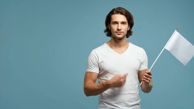 Caucasian man holding a blank white flag, pointing to a copy space on a blue background, then looking forward.