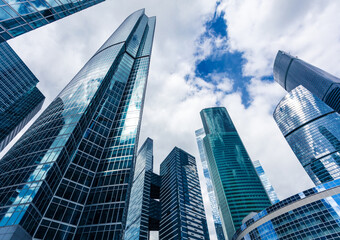 Low angle view of modern skyscrapers against a cloudy sky in an urban financial district area scene