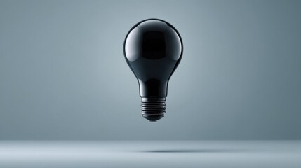A sleek glossy black light bulb floats above a reflective surface against a gradient gray background,