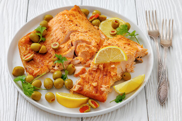 roasted salmon fillet on plate with green olives