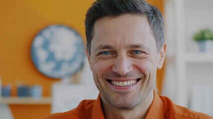 Smiling man with bright blue eyes, closeup, looking directly at the viewer, with warm orange tones
