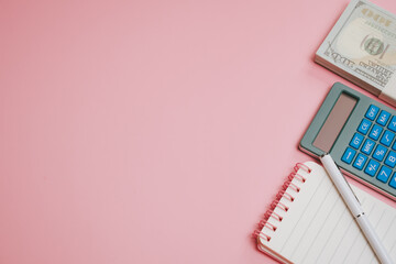 Calculator pen notebook money finance concept with pink background for business planning and accounting