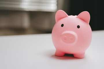 Pink piggy bank saving money finance concept cute pig shape minimalistic design soft lighting white surface blurred background