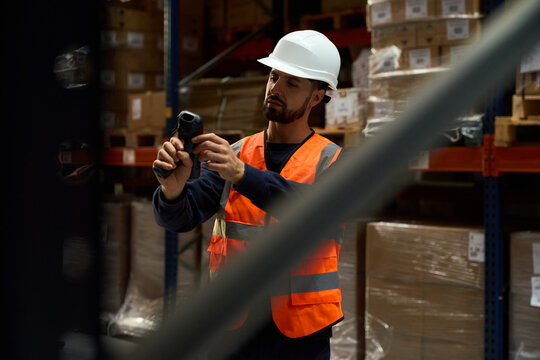 Warehouse worker scanning barcodes managing inventory and logistics - Powered by Adobe