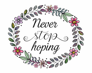 Fototapeta premium Never stop hoping motivational quote surrounded by floral wreath