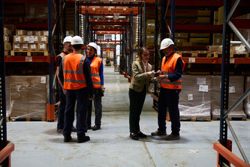 Warehouse manager discussing logistics with workers