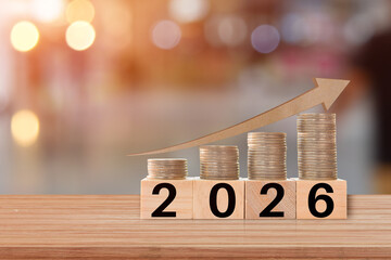 Graph of coins economics growth on wood cubes. Concept success in 2026 year. copy space.