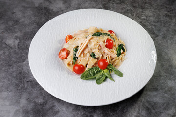 Creamy Pasta with Cherry Tomatoes, Spinach, and Basil on White Plate,Elegant Dinner Presentation
