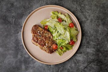 Savory Pan-Seared Steak With Crisp Salad On Beige Plate Over Dark Surface