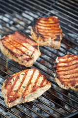 Grilling pork chops on barbecue with sear marks