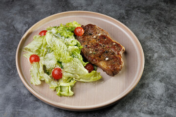 Savory Pan-Seared Steak With Crisp Salad On Beige Plate Over Dark Surface