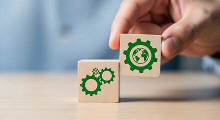 Hand placing wooden block with green earth gear symbol next to block with interlocking gear symbols for sustainability concept