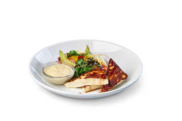 Grilled halloumi cheese salad with dressing on plate