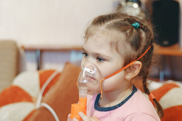 Inhalation therapy for a child at home, a girl with a nebulizer during respiratory therapy