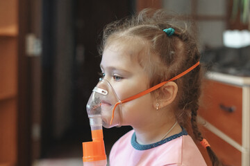 A child uses an inhaler with a clear mask during breathing therapy at home