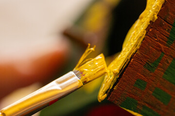 Shallow DOF image of woman painting a small birdhouse arts and crafts concept