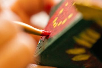Shallow DOF image of woman painting a small birdhouse arts and crafts concept