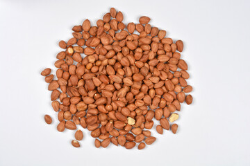 A large, irregular pile of shelled and skin-on hazelnuts is scattered across a plain white background, viewed from above