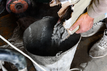 Mixing ceramic tile adhesive in a bucket with mixer.