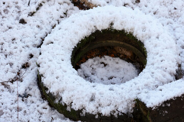 A Discarded Rubber Tire Half Buried In Snow In The Woods. Concept Of Environmental Pollution And...