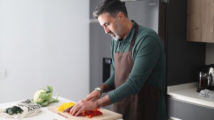 Man chopping fresh healthy vegetables on cutting board