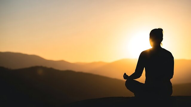 Silhouette of a person meditating in a peaceful yoga pose against a vibrant golden sunset over rolling mountains symbolizing mindfulness and tranquility - Powered by Adobe