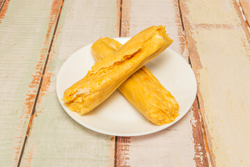 Sweet humitas with ground corn, raisins, cinnamon, and sugar, steamed in their own corn husks