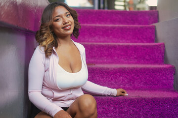 Smiling woman sitting on purple residential staircase