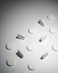 White round tablets scattered on surface creating minimal background for pharmacy, healthcare, treatment and drug concepts