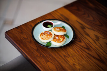 Delicious Golden Pan-Fried Dumplings on Plate with Berry Sauce and Fresh Mint Garnish