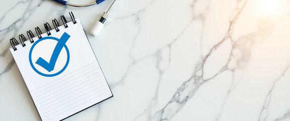 Notepad with checkmark symbol on marble surface for flu vaccination  