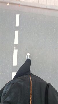 A solitary walk across a city sidewalk, captured from a first-person perspective