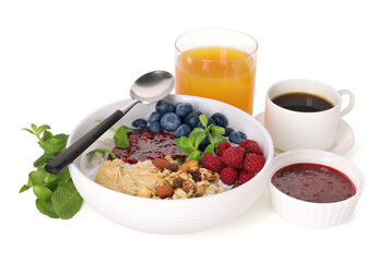 Healthy breakfast. Oatmeal with nuts, berries, jam, coffee and juice isolated on white