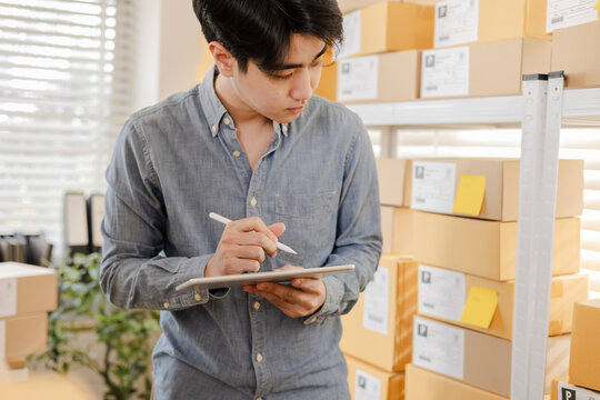 Small business warehouse worker inventory checking and working with tablet technology support accurate stock updates, parcel organization, order control, efficient ecommerce shipping in modern storage
