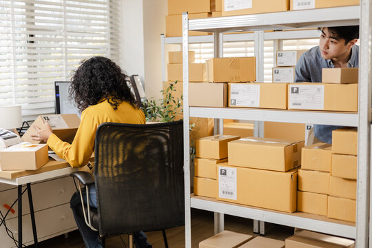 Small business warehouse worker inventory scanning and working process using tablet technology for stock updates, order control, parcel organization, shipping workflow in modern storage workpace