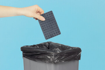 Throwing black playing card into the trash can, outstretched hand with playing card in front of trash can	