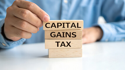 Capital gains tax message on wooden blocks held by a person