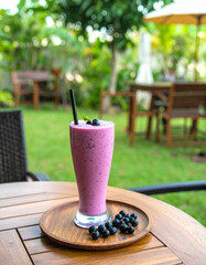 A glass of purple smoothie with a straw in it