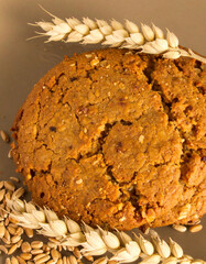A cookie with oatmeal on top of a brown background