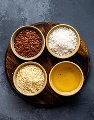 Four bowls of different spices and seasonings are on a wooden table