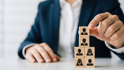 Business person building a team with wooden blocks representing employees
