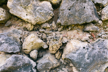 Detailed natural close-up view of rough textured multicolored beach stones, pebbles, and gravel from the sea.