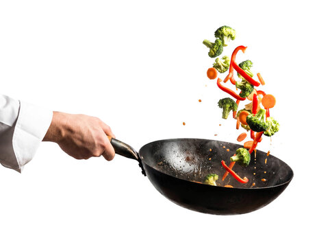 Chef hand tossing vegetables stir fry frying pan isolated white background png transparent cutout cooking healthy food vegan vegetarian broccoli pepper carrot motion action culinary studio shot 