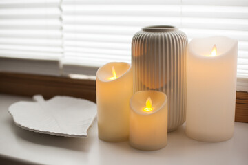 Led battery candles, tray and vase over white background with soft window light.