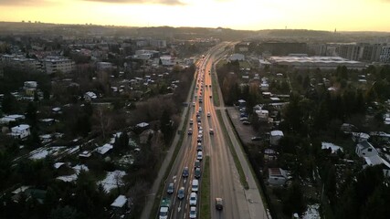 Aerial view transitions to a road with moving cars at sunset, capturing the vibrant colors and dynamic atmosphere, showcasing the beauty of urban life and traffic flow