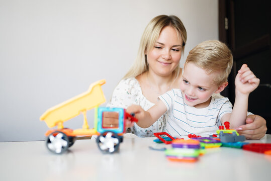 A young boy builds a magnetic STEM construction toy at home, developing problem-solving abilities, creativity and fine motor skills through hands-on educational play.