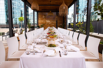 Long set table on terrace with city view - elegant table setting for event